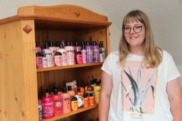 Lisa Ritter vor einem Teil ihrer bunten Duschgel-Sammlung, die farblich sortiert und somit dekorativ im Wohnzimmerschrank ihren Platz gefunden hat. - © Nadine Uphoff