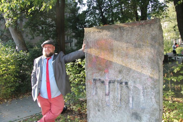 Steffen Stelzer posiert an dem Stück Berliner Mauer auf dem Willy-Brandt-Platz. - © Jana Beckmann