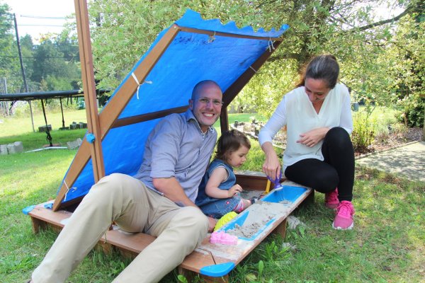 Martin Thiel und seine Frau Manuela Thiel spielen gemeinsam mit Töchterchen Romy-Franziska im Sandkasten im Garten. Auch das Trampolin im Hintergrund wird ab und an genutzt. - © Nadine Uphoff
